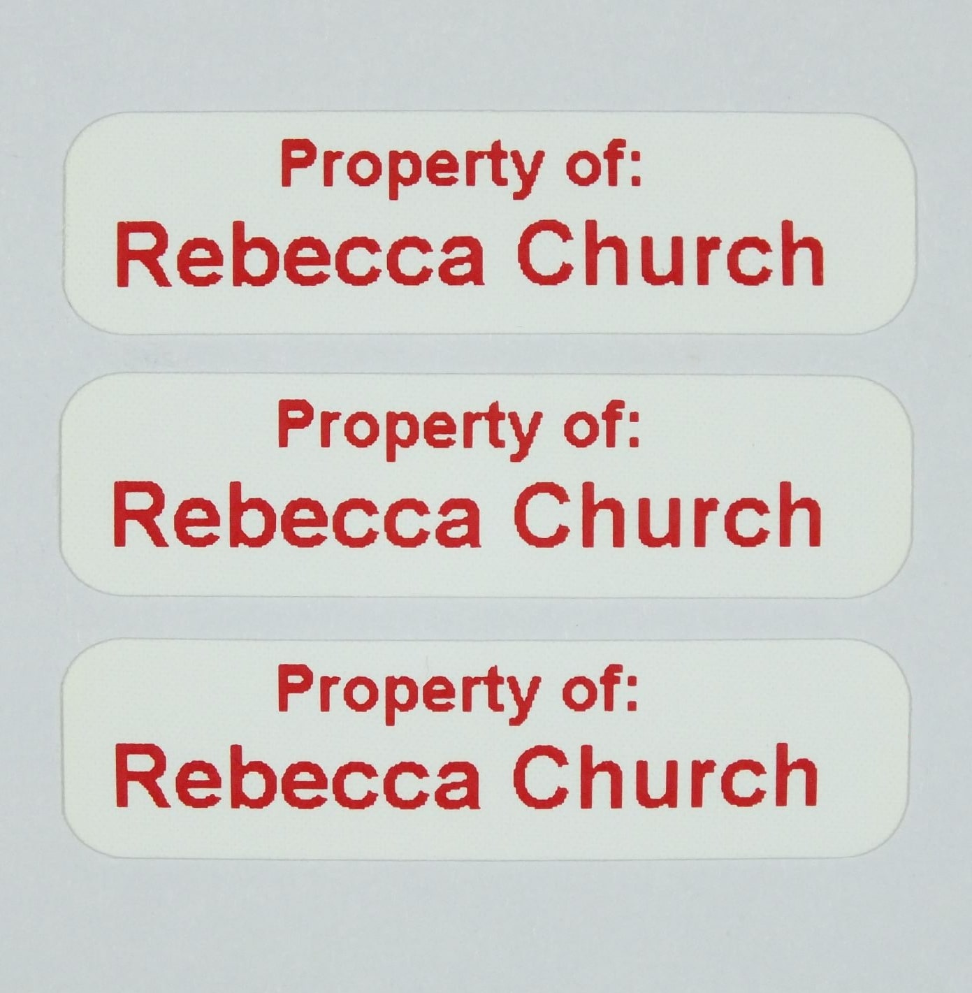 Die-Cut Iron-On Nametapes with rounded corners printed in Red. Ready to apply with a domestic iron.