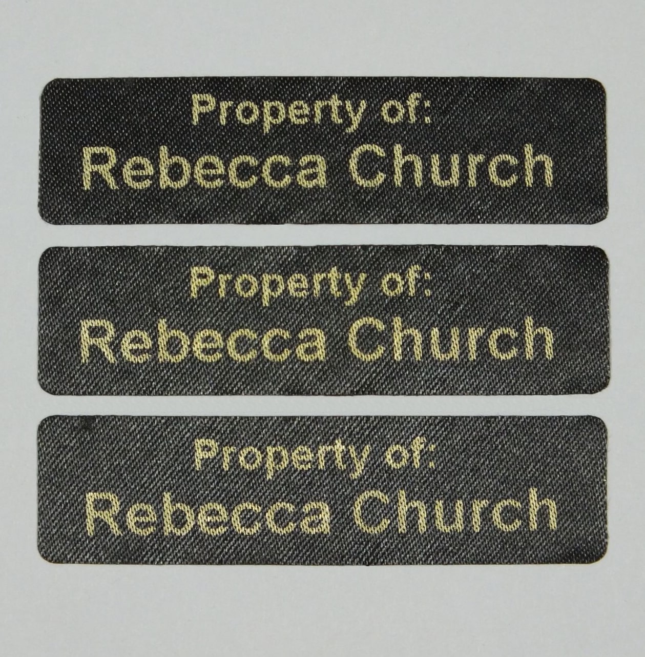 Pre-Cut Iron-On Name tags with rounded corners printed in Silver. Ready to apply with a domestic iron.