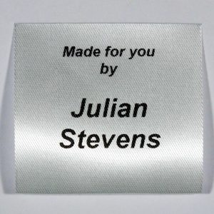 A sew in personalised clothing label printed in Black on Silvery White material