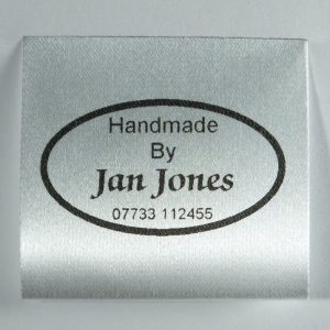 A classic oval design personalised garment label and Care label printed in Black
